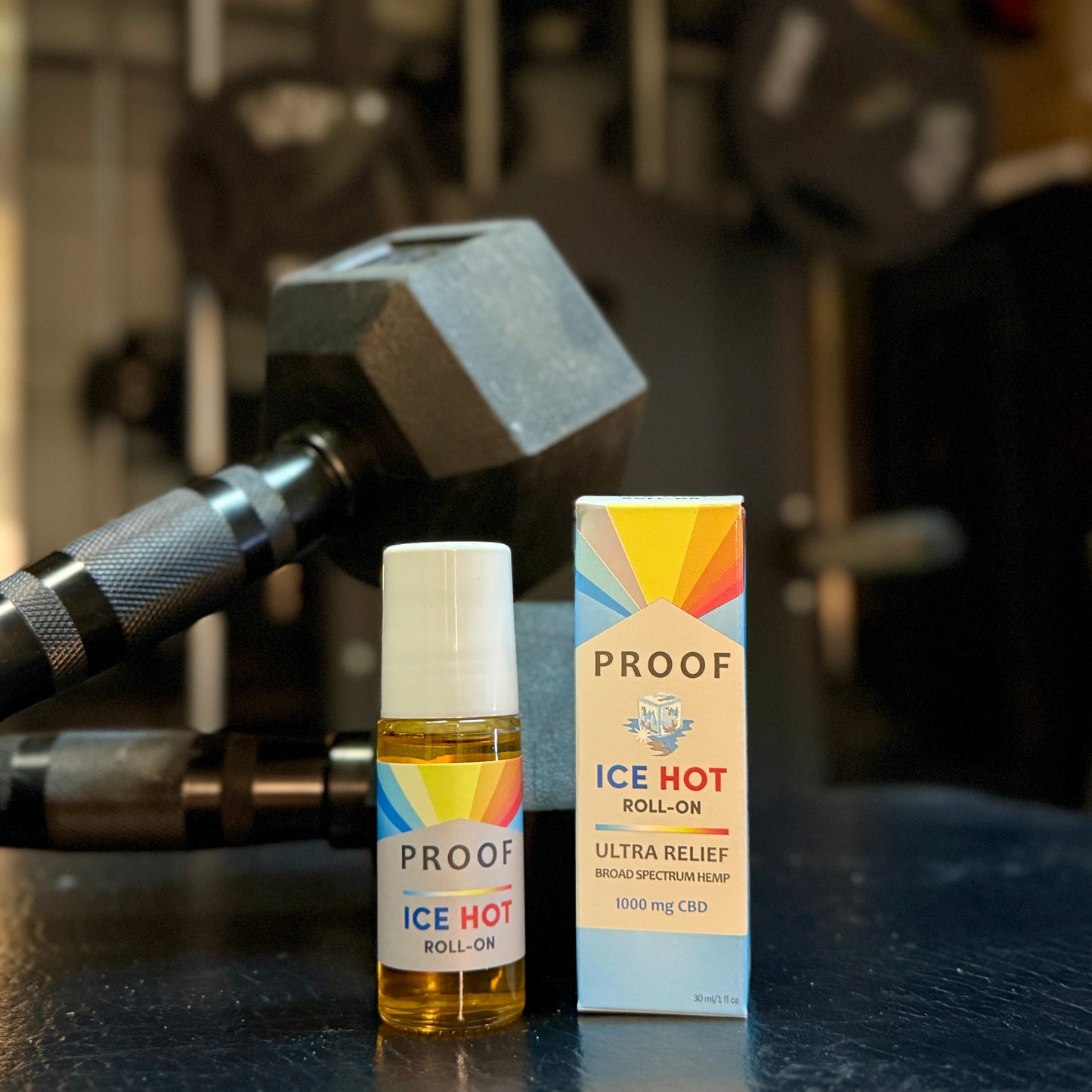 Proof Remedy Ice Hot Roll-On with 1000 mg CBD broad spectrum hemp placed beside a dumbbell for post-workout muscle and joint relief.