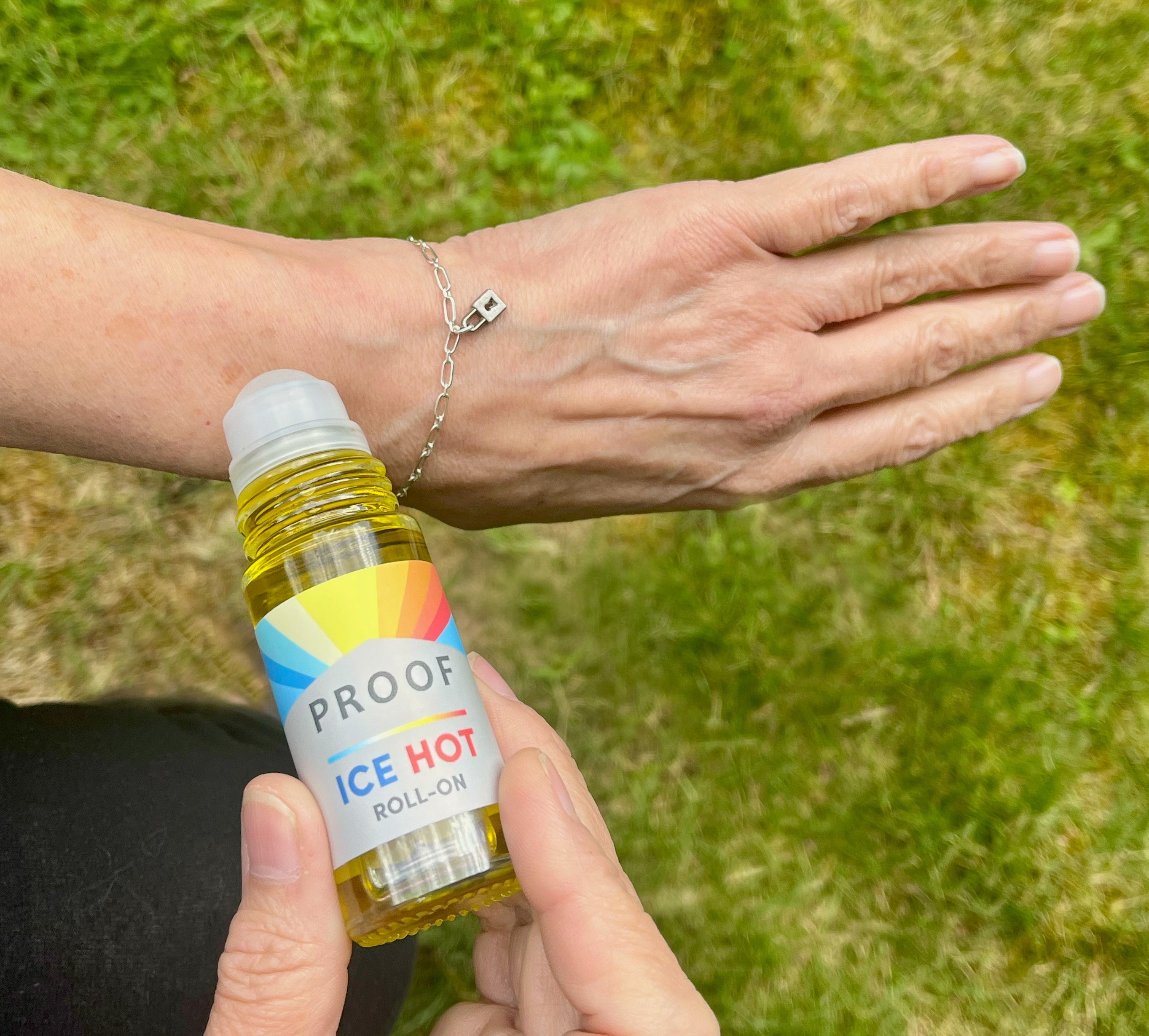 Person applying Proof Remedy Ice Hot Roll-On topical to wrist for natural muscle and joint pain relief.