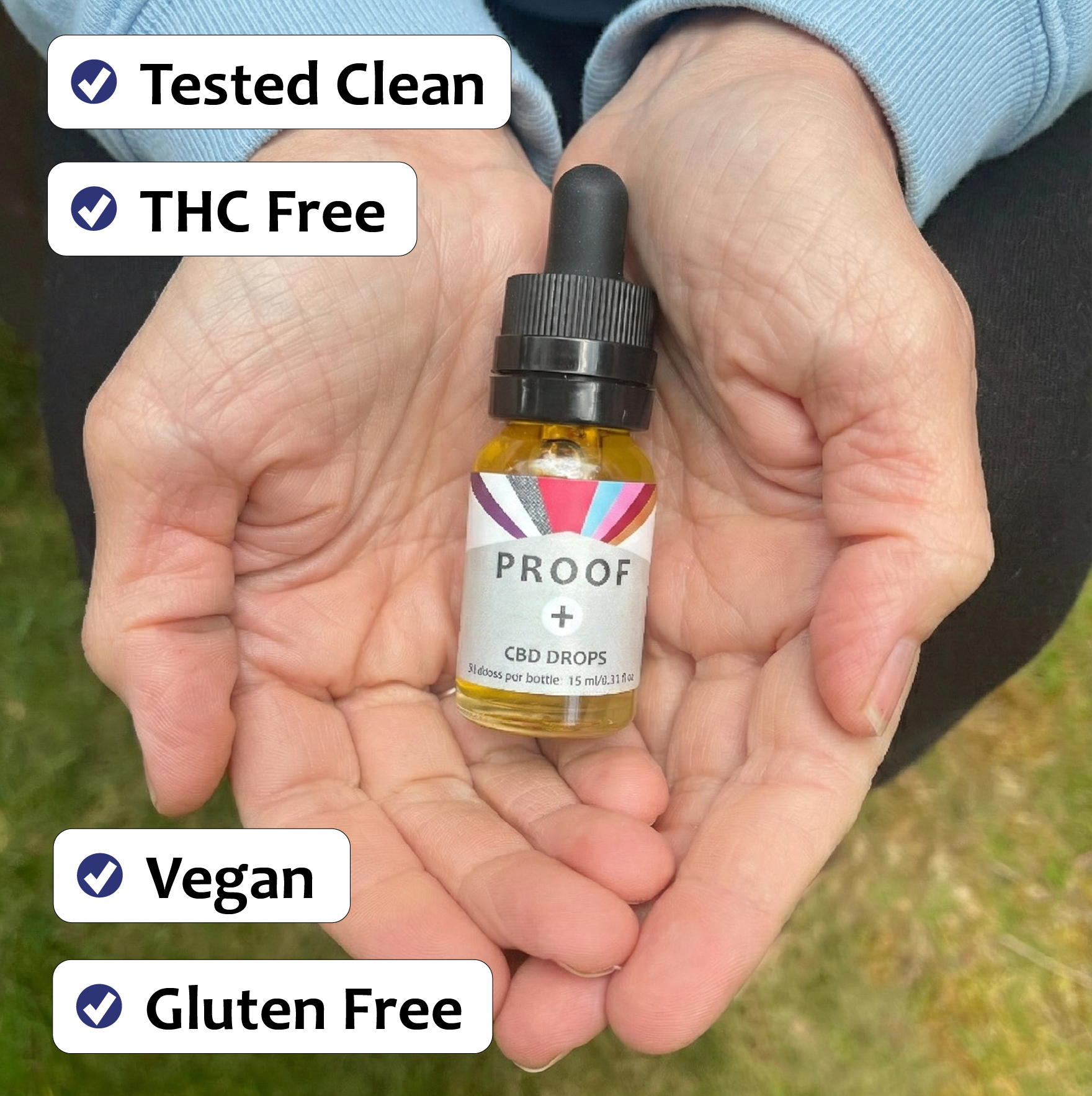 CBD Comfort drops bottle held in hands with 'Tested Clean', 'THC Free', 'Vegan', and 'Gluten Free' labels.