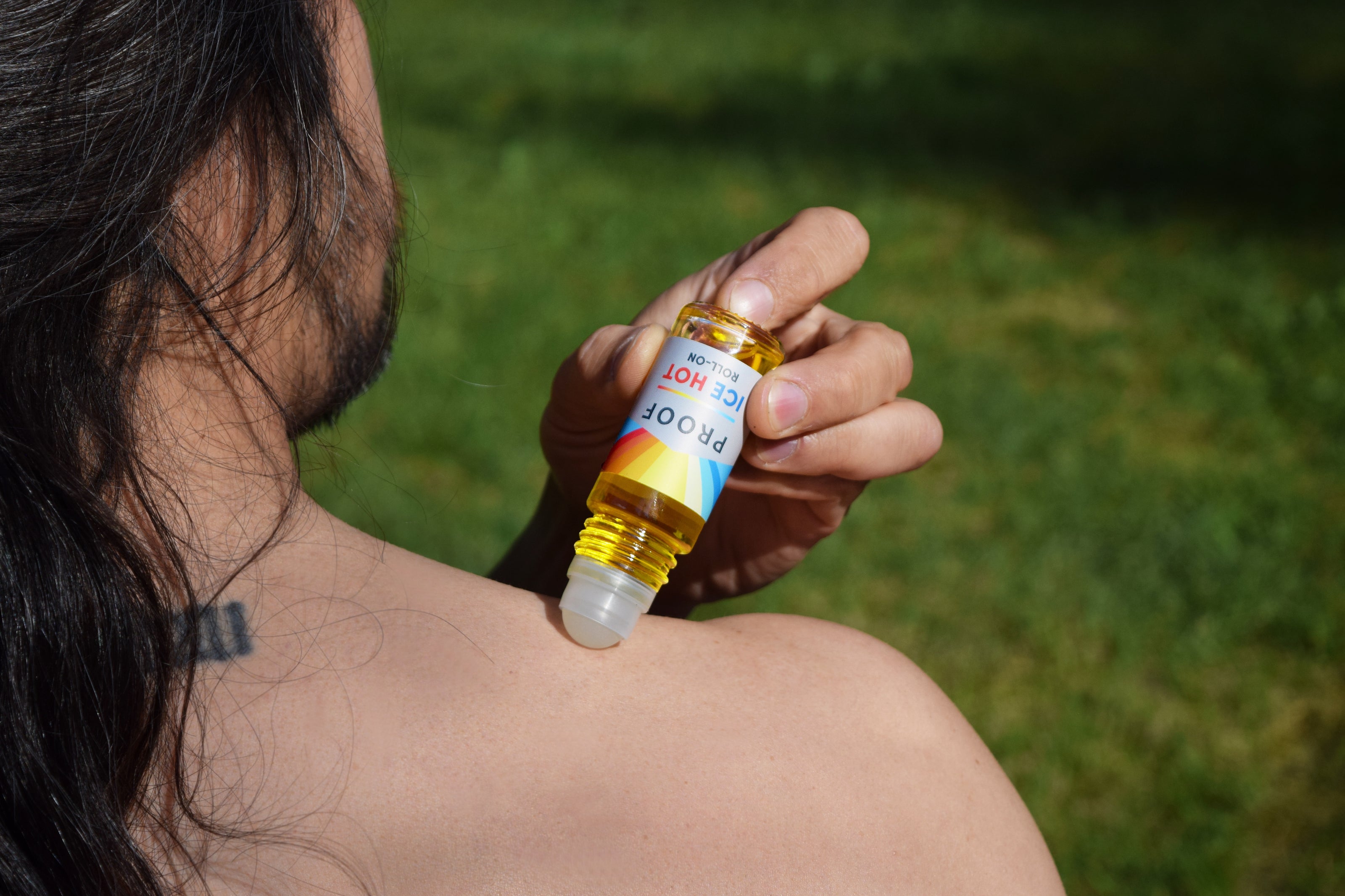 Man applying Proof CBD Ice Hot Roll-on to his shoulder.